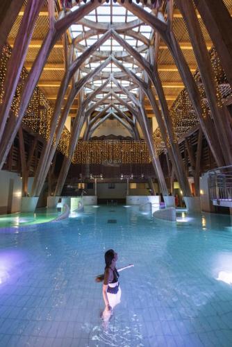 une femme debout dans une piscine dans l'établissement LE LAMARTINE, appartement de charme au coeur de Bagnères, à Bagnères-de-Bigorre