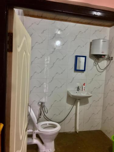 a bathroom with a toilet and a sink at Payun Homestay in Mirik