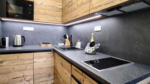 a kitchen with a sink and a counter top at Mountain Apartment Resident - relax s wellness, terasou a soukromou garáží in Harrachov