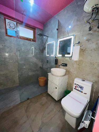 Un baño con un inodoro blanco y un lavabo. en Hotel Oscar, en Kasol