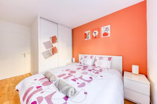 une chambre avec un grand lit avec un mur orange dans l'établissement Terracotta Room - Proche Stade de France & CDG & Paris, à Saint-Denis