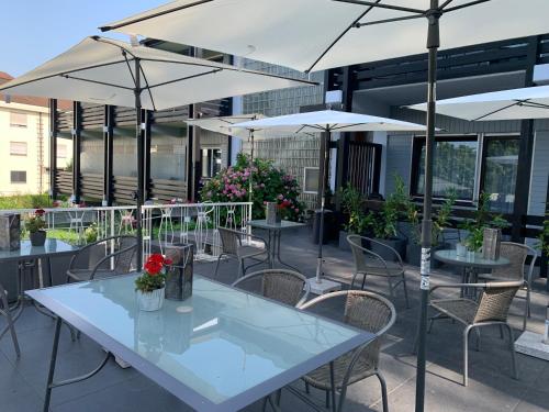an outdoor patio with tables and chairs with umbrellas at Markgraf Eintel in Bad Bellingen