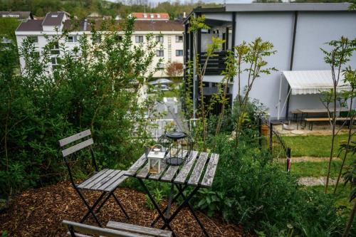 a small table and chair in a garden with buildings at Markgraf Eintel in Bad Bellingen