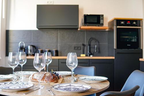 a table with wine glasses and bread on it in a kitchen at EssenFusion Wasserturm - Innenstadt nahe der Messe, SmartTV, Nespresso, Fully Kitchen in Essen