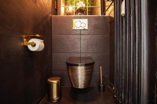 a bathroom with a gold toilet in a room at EssenFusion Wasserturm - Innenstadt nahe der Messe, SmartTV, Nespresso, Fully Kitchen in Essen