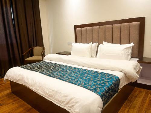 una camera d'albergo con un grande letto con una coperta blu di Chubi Sponbo a Leh