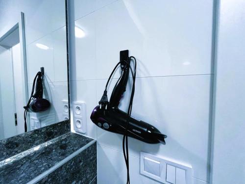 a black phone hanging on the wall of a bathroom at Bella Apartments Brno in Brno
