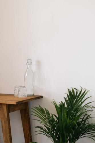 a table with a bottle on it next to two plants at Sansun Guesthouse in Mirissa