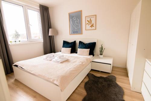 a bedroom with a white bed and a window at Loomená Apartments - Free Garage in Košice