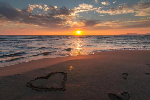 a heart drawn in the sand on the beach at sunset at Villa Caylee Caribbean Estates - Ultra-Luxurious - Rimas Interiors Designs - Private Beachfront Escape - Premium serviced for 8 Guests in Port Edward