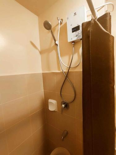 a bathroom with a shower and a toilet with a blow dryer at 1517 double in Iloilo City