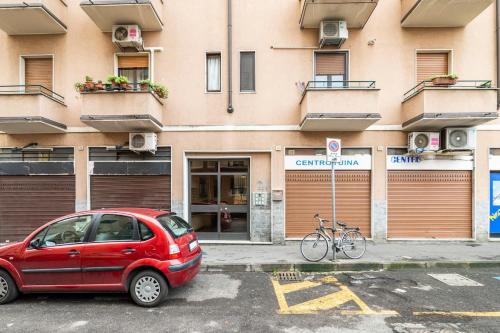 a red car parked in a parking lot in front of a building at EMMAS Home cologno monzese in Cologno Monzese