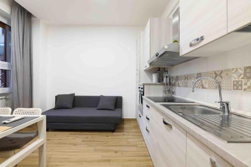 a kitchen with a sink and a couch in a room at EMMAS Home cologno monzese in Cologno Monzese