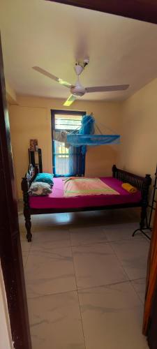 a bedroom with a bed and a ceiling fan at Tony's Garden House Back Packers inn in Jaffna