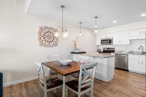 a kitchen and dining room with a wooden table and chairs at Cotton Bayou 7H by Vacation Homes Collection in Orange Beach