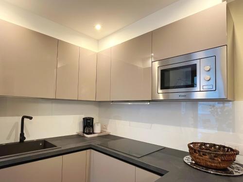 a kitchen with white cabinets and a microwave at Residenza I Melograni - Suite in Domaso