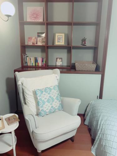 a white chair with a pillow in a bedroom at Airportside Chillhouse in Toyonaka