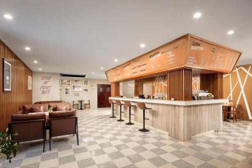 a lobby with a bar and a counter with chairs at Angkor Mansion & Residence in Siem Reap
