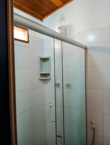 a bathroom with a shower with a glass door at Pousada Lagoa Da Pedra in Imbassai