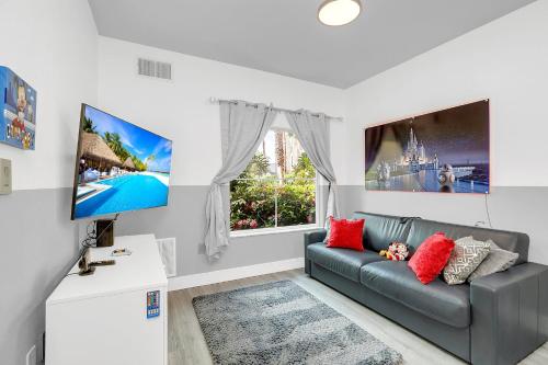 a living room with a couch and a tv at Disney Accessibility Star Wars Vacation Apartment Near Parks in Orlando