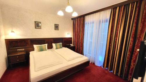 a bedroom with a large bed and a window at Hotel-Restaurant Batzenhäusl in Innsbruck