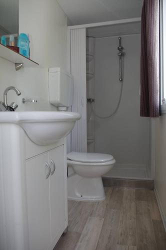 a white bathroom with a toilet and a sink at Camping Golden Sunset in Alissos