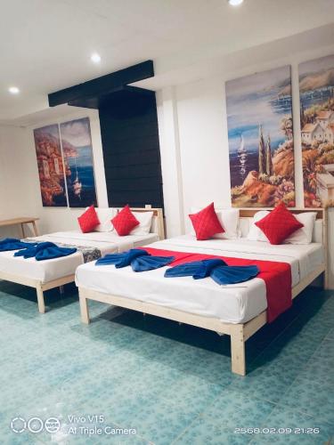 three beds in a room with red and blue pillows at Big Family Bungalow Near Swiming Pool in Ko Chang