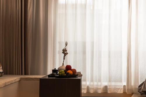 a bowl of fruit on a table in front of a window at Shangri La Yi Shan Ban Yun Inn in Shangri-La