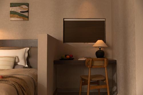 a bedroom with a bed and a table with a lamp at Shangri La Yi Shan Ban Yun Inn in Shangri-La