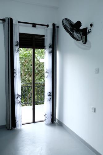 an empty room with a door open to a balcony at AQUARIUS Stay in Tangalle