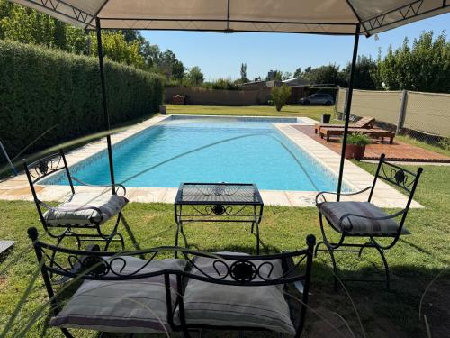 a pool with two chairs and a table and an umbrella at Vultur in San Rafael