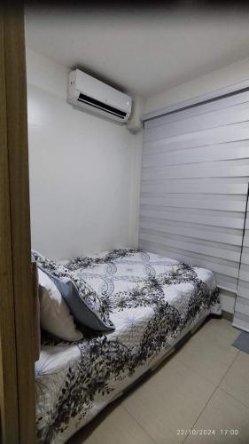 a bedroom with a bed and a window with a heater at Shore 2 Tower 1 JMB Staycation in Manila