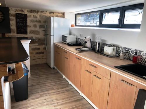a kitchen with wooden cabinets and a refrigerator at Chambres d'Hôte Dijon Clair de Lune Adults Only in Chenôve