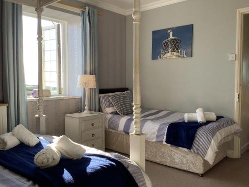 a bedroom with two beds and a bird cage at Haelarcher Farmhouse and Helicopter B&B in Lizard