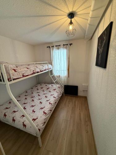 - une chambre avec des lits superposés et un plafond dans l'établissement Appartement 2 pièces, les Chalets de Super-Besse, à Besse-et-Saint-Anastaise