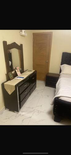 a bedroom with a bed and a dresser with a mirror at The Garcias Village C with Jacuzzi ACNetflix in La Alianza