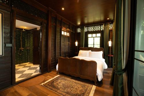 a bedroom with a bed and a large window at Akara House Sukhothai - Luxury Riverside Residence in Sukhothai