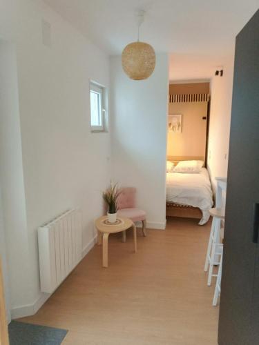 une chambre avec un lit et une table avec une plante en pot dans l'établissement cocon, à Marquise