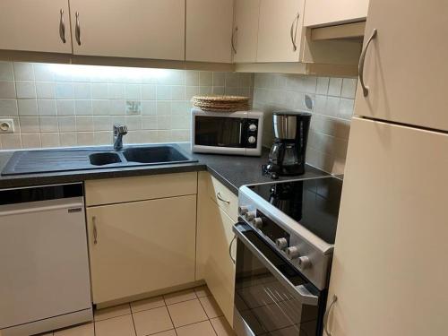a kitchen with a sink and a microwave at Orlyvo appartement Middelkerke in Middelkerke