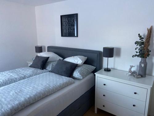 a bed with pillows on it next to a night stand at Haus Schwaighof in Arzl im Pitztal