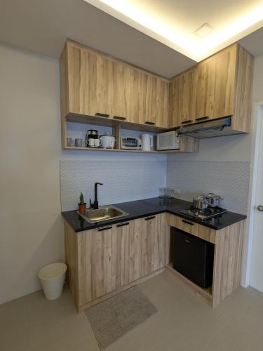a kitchen with wooden cabinets and a sink at Couple Suite with Ocean View & Relaxing Tub Batangas in Lobo