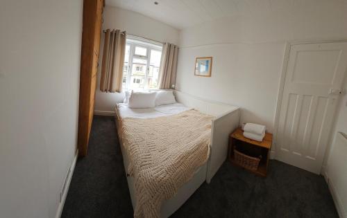 a small bedroom with a bed and a window at Maureen's Hideaway in Penrith