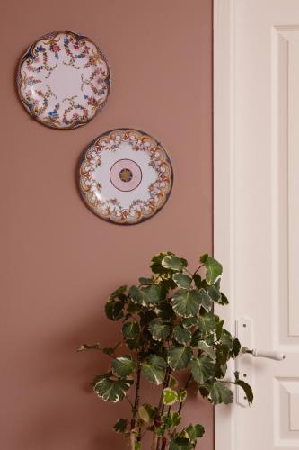 two plates hanging on a wall with a plant at Le Domaine de Villespy in Villespy