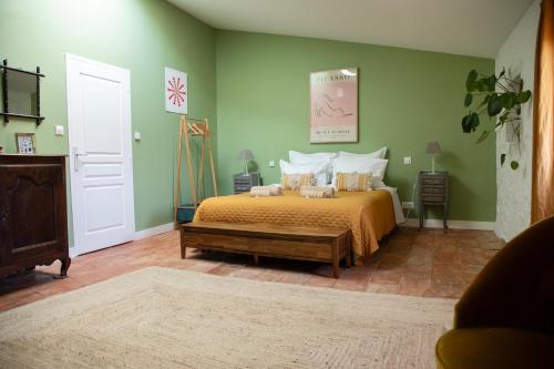 a bedroom with a bed and green walls at Le Domaine de Villespy in Villespy