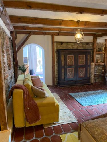 a living room with a yellow couch and a fireplace at Sokograd Royal in Šipovo