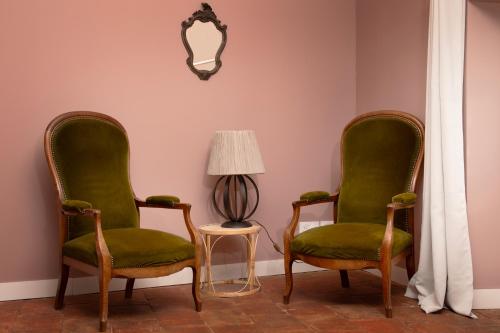 a room with two green chairs and a lamp at Le Domaine de Villespy in Villespy