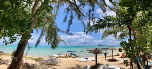 a beach with chairs and boats in the water at sea beach pool in Bain Boeuf