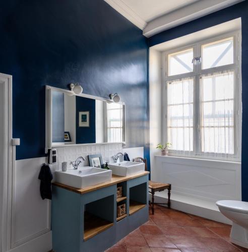 a bathroom with two sinks and a blue wall at Le Domaine de Villespy in Villespy
