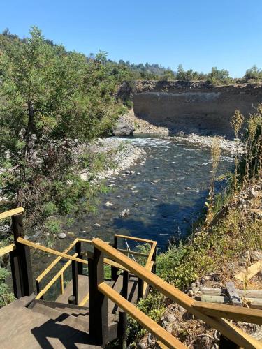 a wooden staircase leading down to a river at Cabañas Cocodrilo Lodge in Molina