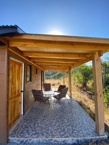 a patio with chairs and a table on a house at Cabañas Cocodrilo Lodge in Molina